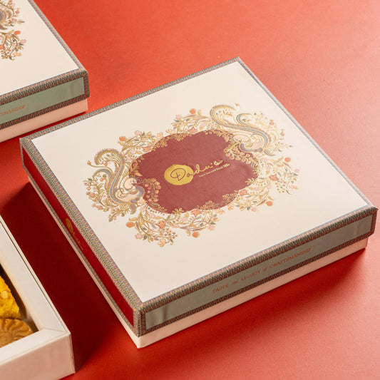 Closed Dadus Diwali gift box with gold foil peacock and floral design on cream lid, ready to send from India to USA UK Canada Australia