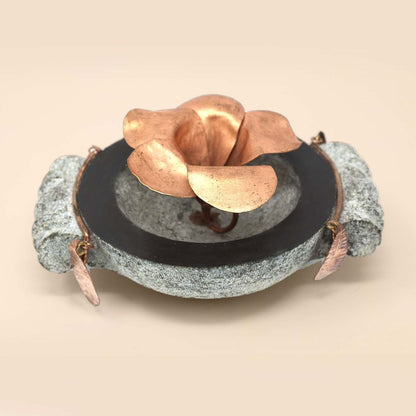 Handcrafted stone uruli with copper flower in the centre.