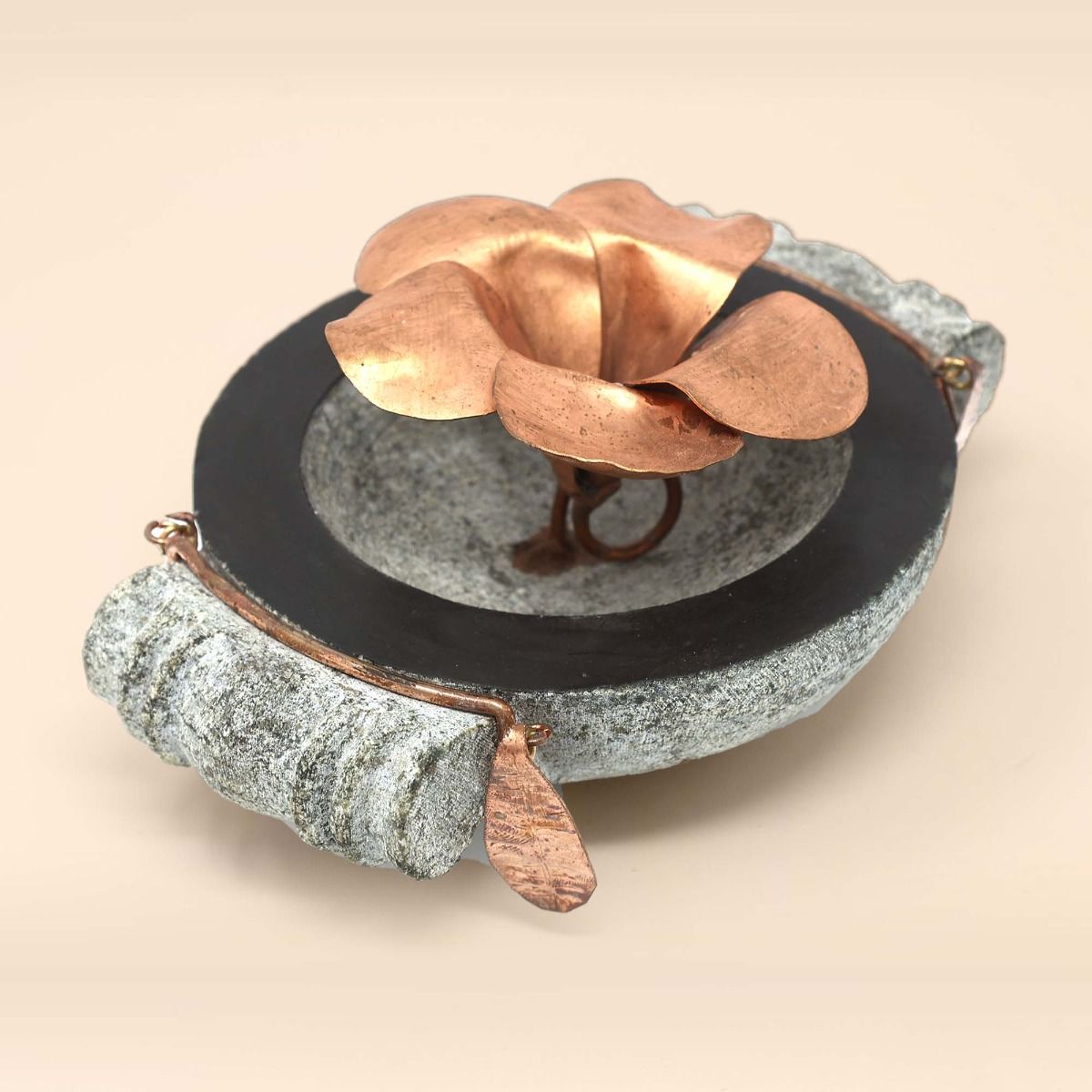 Handcrafted stone uruli with copper flower in the centre.