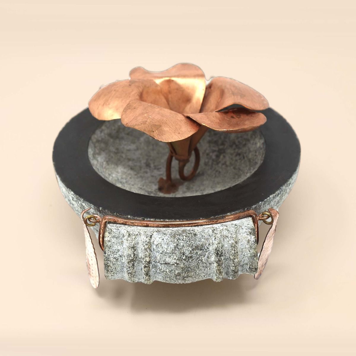 Handcrafted stone uruli with copper flower in the centre.