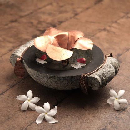 Handcrafted stone uruli with copper flower in the centre.